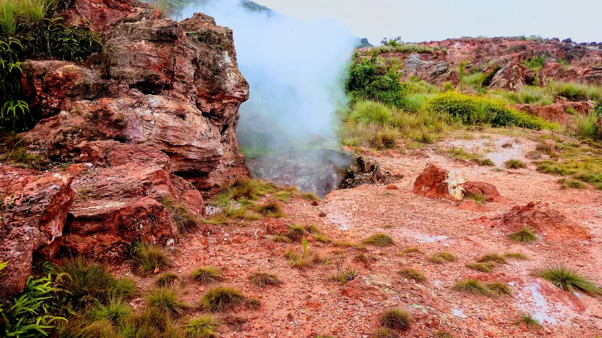 Geothermal steam rising from red rocks and grass in the Eburru hills